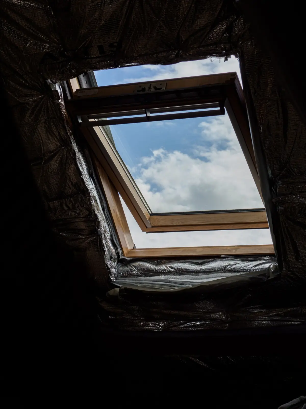 Fenêtre de toit ouverte sur le ciel dans des combles