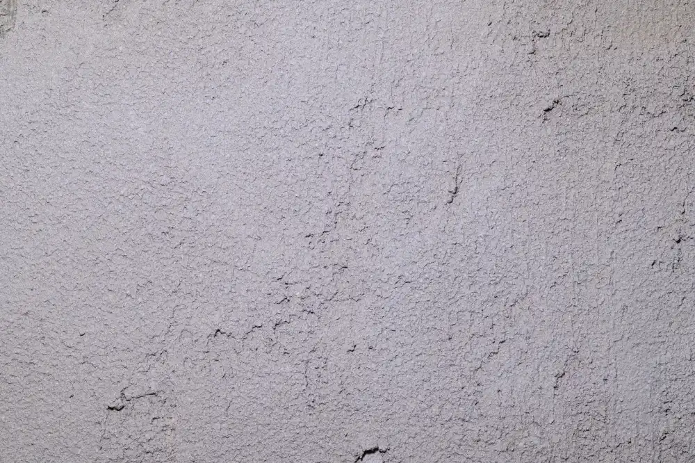 Mur enduit à la texture minérale sous la lumière du jour